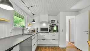 A modern kitchen with white cabinetry, a built-in oven, a microwave, and a dishwasher. - 3 bedroom gorgeous home in Oksbøl (Oksbøl)