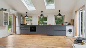 A modern kitchen with skylights, a built-in oven, and a washing machine. - Awesome home in Nykøbing Sj with WiFi (Nykøbing Sj)