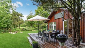 A wooden deck with outdoor furniture, a barbecue grill, and a large umbrella. - Awesome home in Nykøbing Sj with WiFi (Nykøbing Sj)