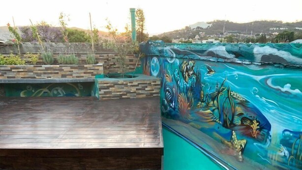 Una terraza de madera con un mural de temática marina.