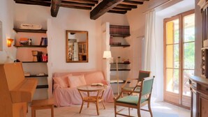 A cozy living room with a sofa, chairs, a coffee table, and shelves with books and decorative items. - Pergola by Interhome (Boccheggiano)