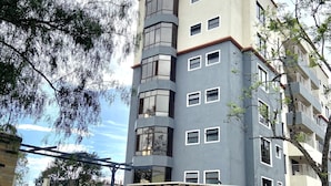 A multi-story residential building with a modern design, featuring a mix of balconies and windows. - Midtown C32 Executive Suites (Nakuru)
