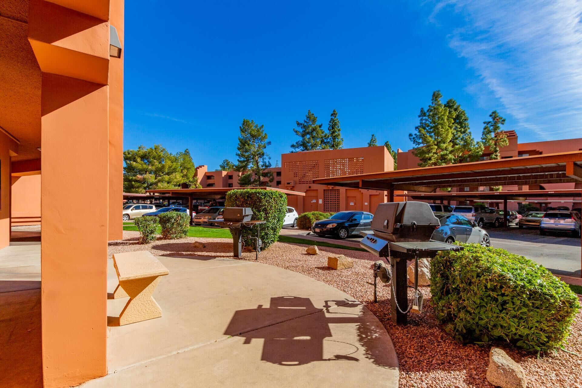 A parking area with barbecue grills and a covered picnic table.