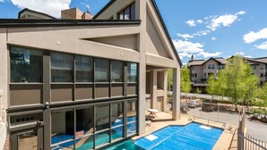 Ein modernes Gebäude mit Schwimmbad, großen Fenstern und einer überdachten Terrasse.