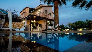 A two-story house with a swimming pool, outdoor seating, and a stone wall. - Villa Sar in Kampani Chania (Chania)