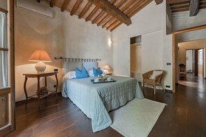 A bedroom with a bed, bedside tables, a lamp, and a chair.