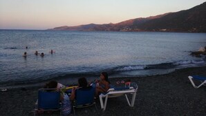Ein Strand mit badenden und entspannten Menschen am Ufer.
