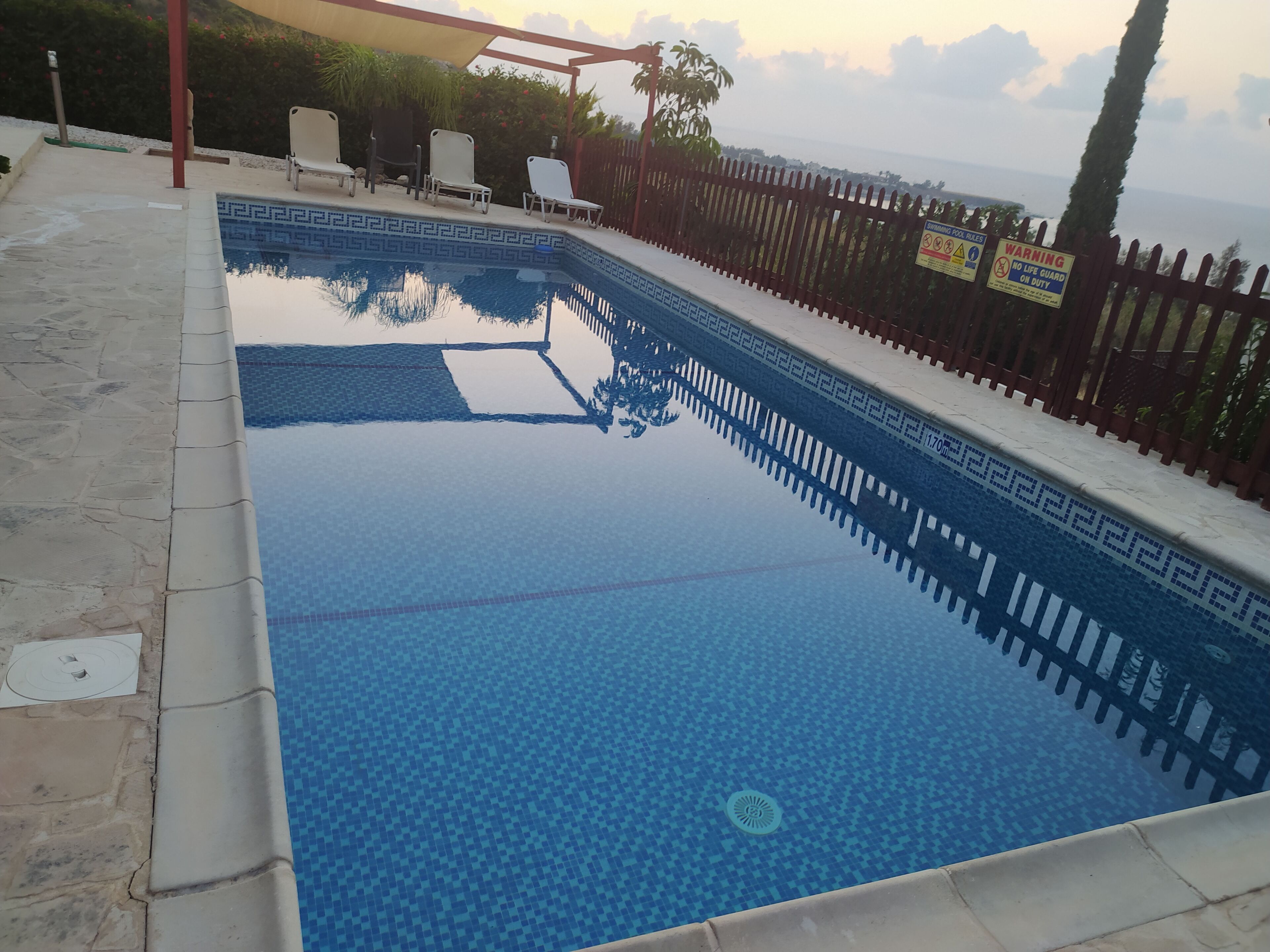 Uma piscina retangular com borda azulejada e superfície de água azul cristalina.