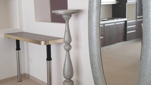 A room with a dining table, a decorative silver mirror, and a small cabinet. - Holiday Home 10 Minutes From Porto Cesareo (San Pancrazio Salentino)