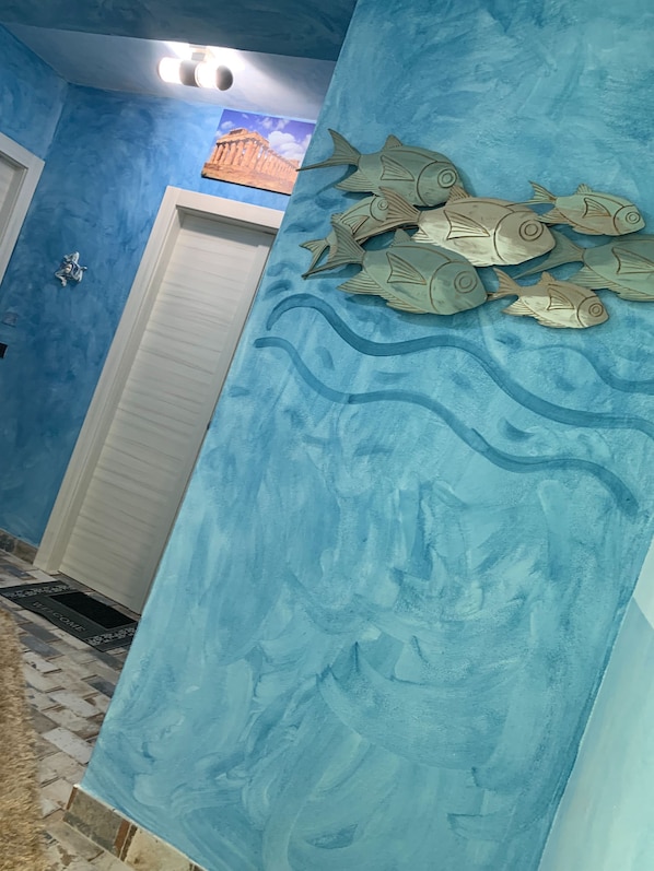 Experience the ocean's charm in this inviting room, featuring a vibrant mural of fish and waves.