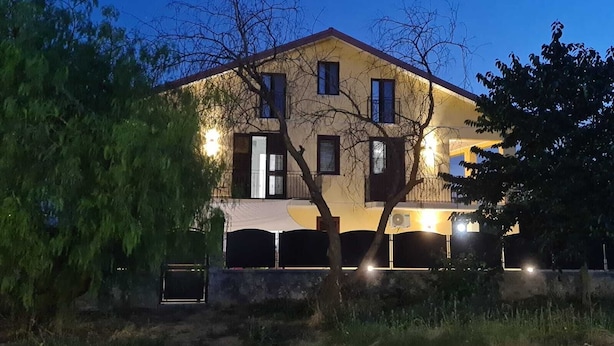 A two-story building with a yellow facade and dark shutters, surrounded by trees. - Room in B&B - B&b Villa Chiara Trappitello Taormina (Taormina)