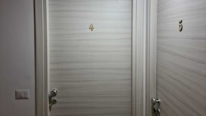 Two doors with numbers 4 and 5, a light switch, and a thermostat on the wall. - Room in B&B - B&b Villa Chiara Trappitello Taormina (Taormina)