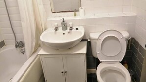 Ein Badezimmer mit Waschbecken, Toilette und Badewanne.