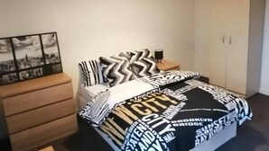 Ein Schlafzimmer mit einem Bett, einem Nachttisch, einer Kommode und einem Kleiderschrank.
