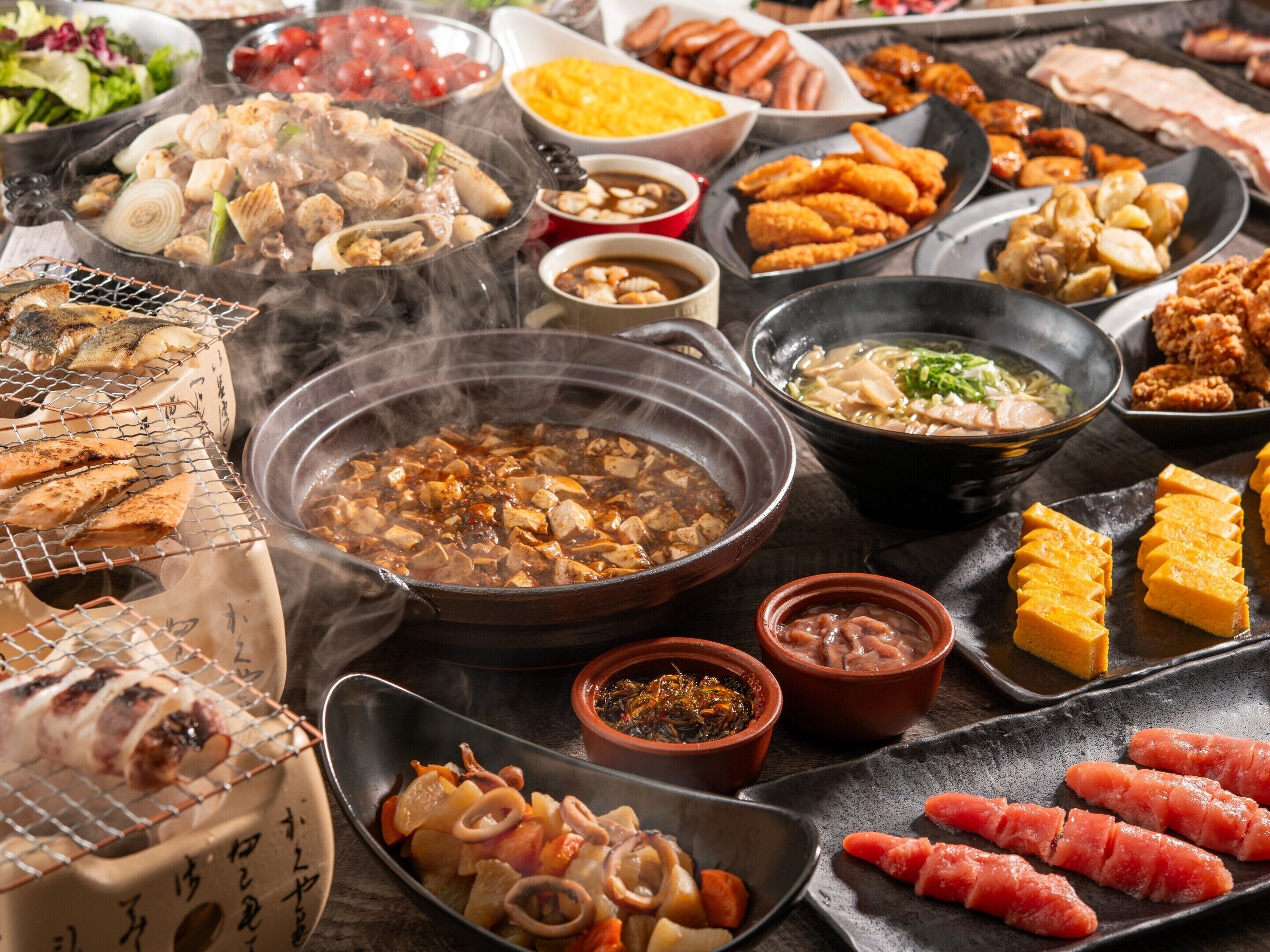 A variety of dishes, including grilled meats, tofu, and vegetables, served on a table.