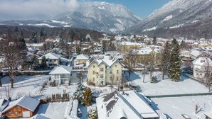 A snow-covered town with houses and mountains in the background.