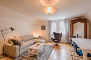 A living room with a sofa, coffee table, armchair, and dining table. - Superior Familien-apartment mit Bergblick - Top 6 - Landhaus Blauer Spatz (Reichenau an der Rax)