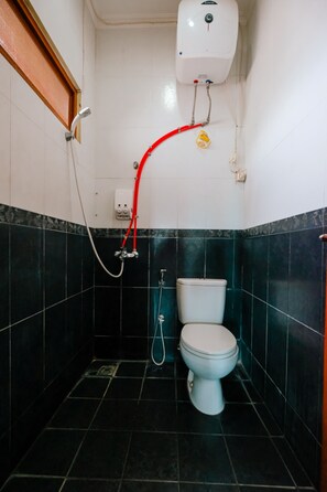 Un baño pequeño con inodoro, ducha y calentador de agua.