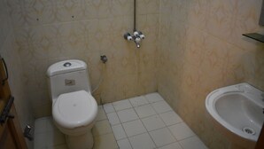 A small bathroom with a toilet, bidet, and sink. - Pearl City Hotel (Peshawar)