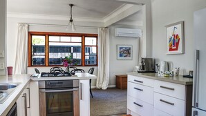 A compact kitchen with a central island, a built-in oven, and a coffee maker. - A private and spacious character home in Khandallah (Wellington)