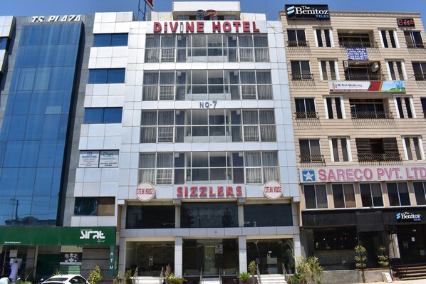 Un immeuble abritant l’hôtel Divine et le restaurant Sizzlers au rez-de-chaussée.