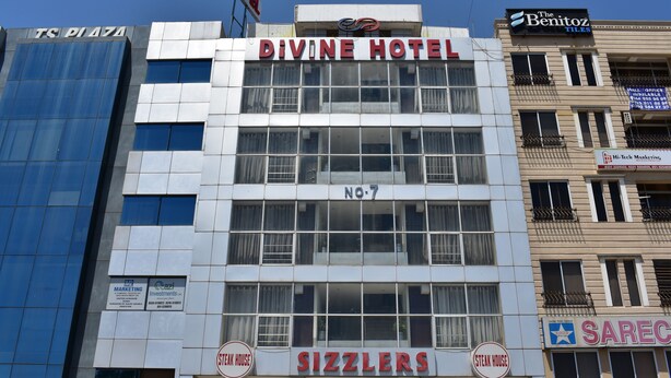 Ein Gebäude mit einer Schrifttafel für 'Divine Hotel' und 'Sizzlers' im Erdgeschoss.