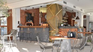 Un espace bar moderne avec un mur en briques, des tabourets de bar et un comptoir doté d’une caisse enregistreuse.