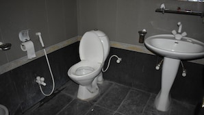 A bathroom with a toilet, bidet, and sink. - Undrah Inn Hotel (New Mirpur City)