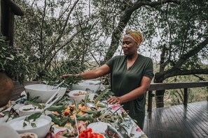 Un espace de restauration en plein air avec une table dressée pour un repas, entouré d’arbres.