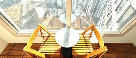 Una habitación con tragaluz, suelo de madera y una mesa redonda con sillas.