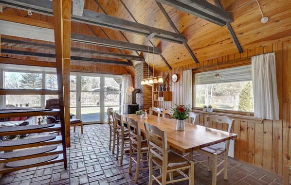 A wooden interior with a dining area, a fireplace, and large windows. - Awesome home in Løgstør with WiFi (Løgstør)