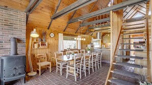 Un interno rustico con camino in mattoni, tavolo da pranzo in legno e sedie.