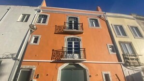 A two-story building with a central balcony and a ground-level entrance. - Setúbal Downtown Blue 0 (Setúbal)