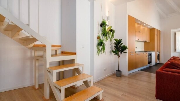 Een modern appartement met een trap, een keuken en een woongedeelte.