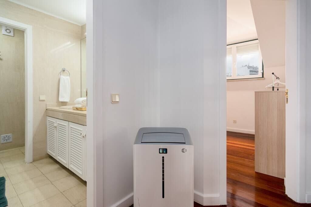 Een moderne badkamer met een douche, toilet en wastafel. Er hangt een witte handdoek aan de muur en een klein raam zorgt voor natuurlijk licht.