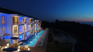 A multi-story hotel with a swimming pool, outdoor seating, and balconies. - Faralya Tuz Hotel (Fethiye)