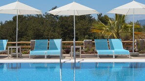 A poolside area with lounge chairs and umbrellas, a clear pool, and a forested background. - Faralya Tuz Hotel (Fethiye)