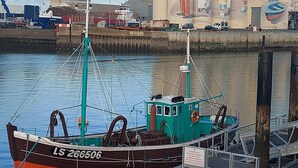 A docked boat with a visible identification number LS 266506.