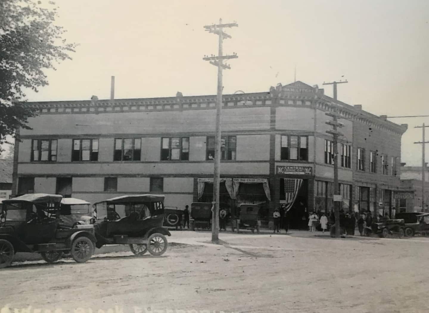 A historic building with a central entrance, multiple windows, and a sign indicating a business.