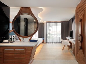 A modern bathroom with a large mirror, a bathtub, and a vanity with a sink and mirror. - The Oceanic Sportel (Ko Kaeo)
