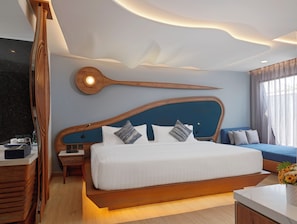 A modern bedroom with a large bed, wooden headboard, and a unique ceiling design. - The Oceanic Sportel (Ko Kaeo)