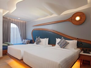A hotel room with two beds, a wooden headboard, a nightstand, and a large window with curtains. - The Oceanic Sportel (Ko Kaeo)