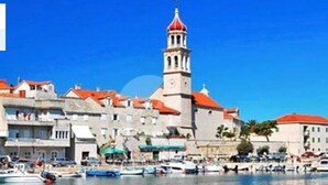A coastal town with a prominent tower and a marina with boats. - Nice 2-bedroom Private House, 50 m Beach, Sutivan (Sutivan)