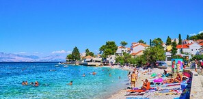 A coastal town with clear blue waters, beachside buildings, and a mountainous backdrop. - Nice 2-bedroom Private House, 50 m Beach, Sutivan (Sutivan)