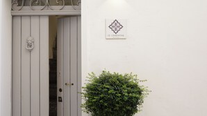 Una puerta blanca con un tirador decorativo y un letrero arriba que dice "LE CEMENTINE".