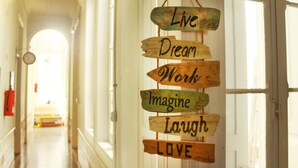 A hallway with a wooden sign hanging on the wall with motivational phrases. - Mahalo Helthy House (Las Palmas de Gran Canaria)