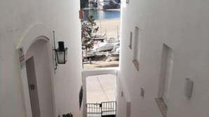 Una stretta scala conduce a un ingresso con cancello, con vista sulla costa.