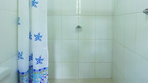 A bathroom with a shower, toilet, and a tiled floor. - VOA Pousada Recanto dos Colibris (Paraty)