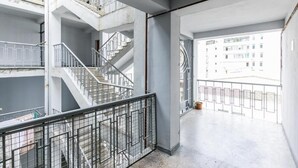 Monitasoinen sisätila, jossa on portaikko, metallikaiteet ja näkymä ulkopuolella oleviin rakennuksiin.