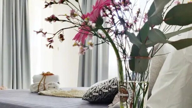 A modern room with a bed, a vase with flowers, and a geometric candle holder on a table. - Emorfia's Apartments No5 - 300m to the beach (Rethymno)